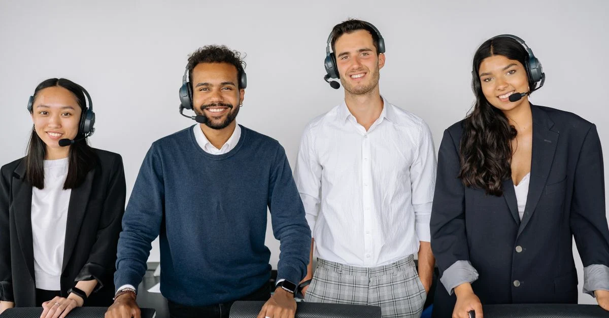Um grupo diversificado de representantes de atendimento ao cliente usando headsets em um escritório moderno. Contexto: Automação de leads: como distribuir, nutrir e acompanhar contatos