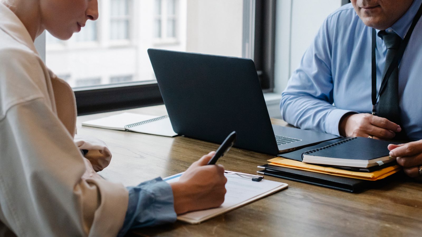Profissionais revisando e assinando um contrato em uma reunião de trabalho