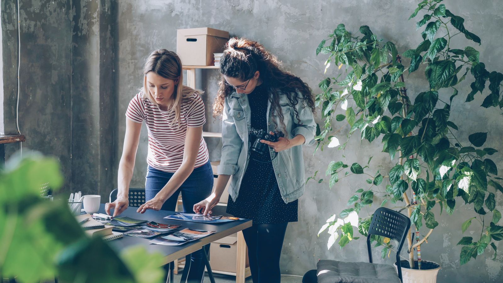 Profissionais revisando fotografias e materiais criativos em uma mesa