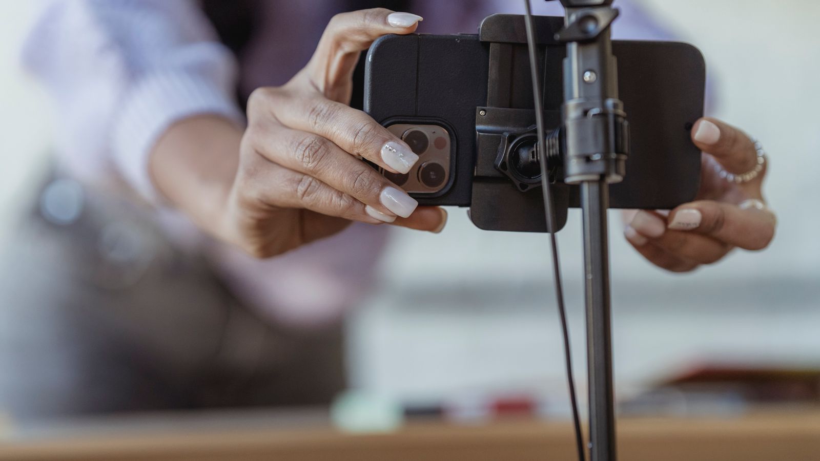 Creator preparando um smartphone em tripé para gravar conteúdo digital